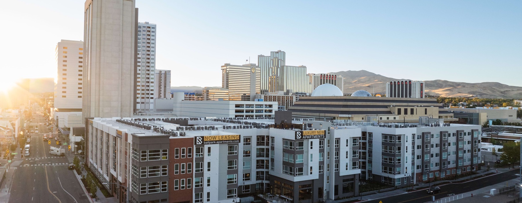 Building exterior of Ballpark apartments in Reno with a mountain in the distance.